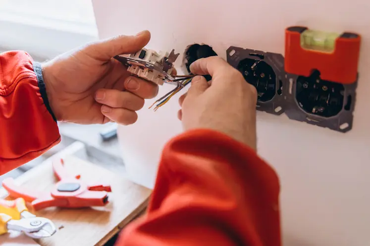 Elettricista al lavoro su un quadro elettrico durante un intervento urgente a Bologna